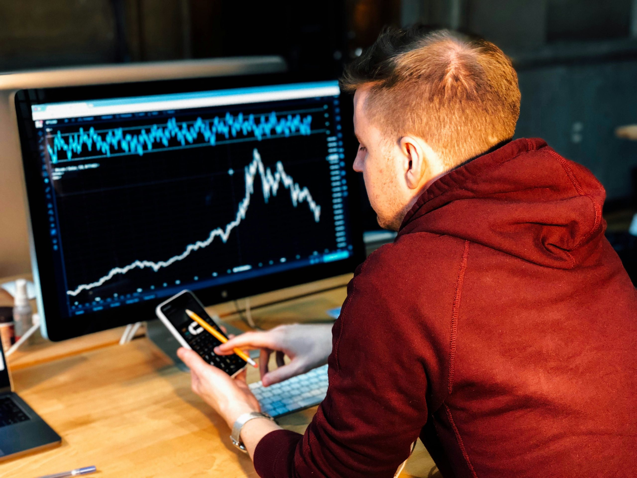Analyzing Trader Performance An individual analyzing financial data on a professional trading platform, using a master trader leaderboard for client conversion.