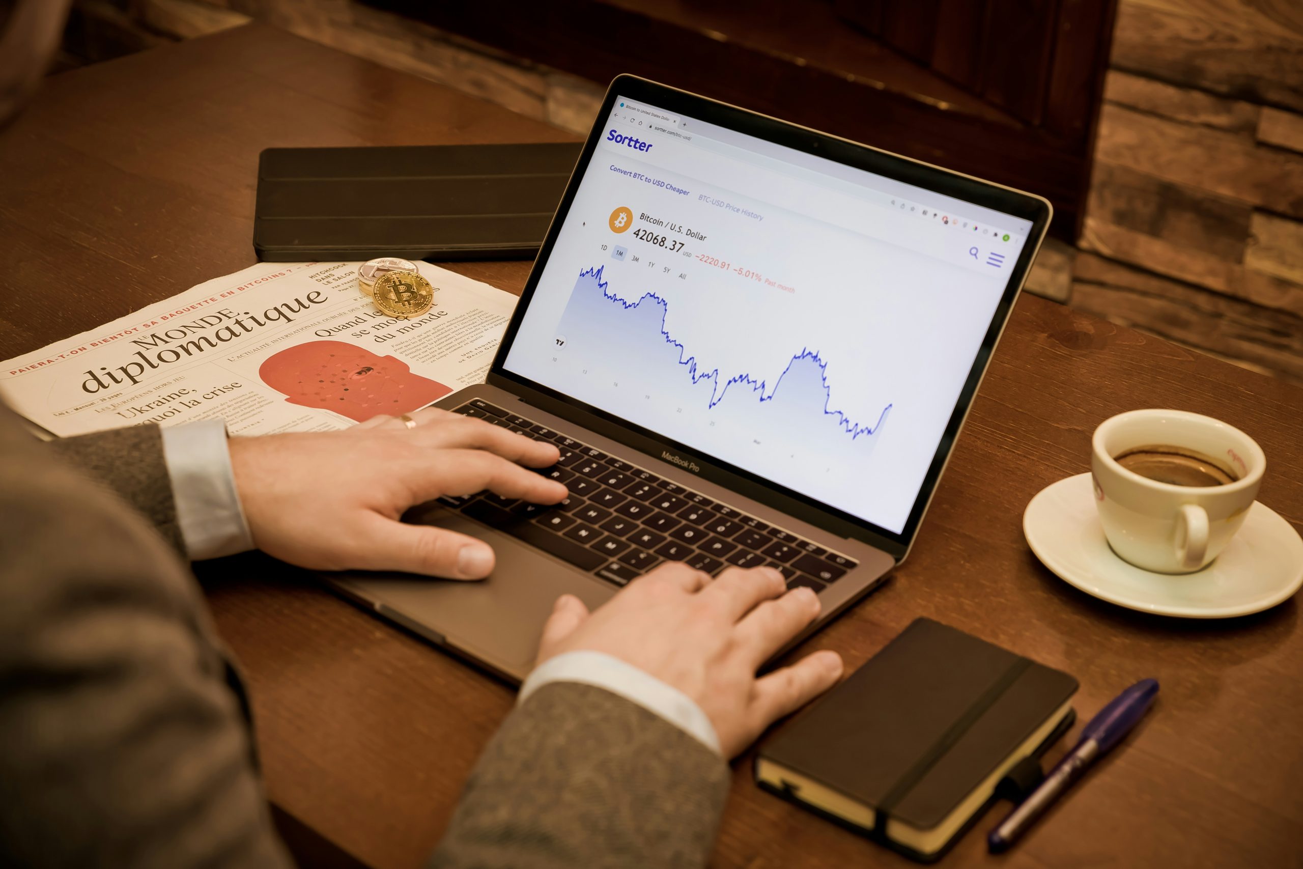Image of hands at a computer, actively monitoring financial data and verifying news, emphasizing critical thinking and due diligence for trading decisions amid market volatility.