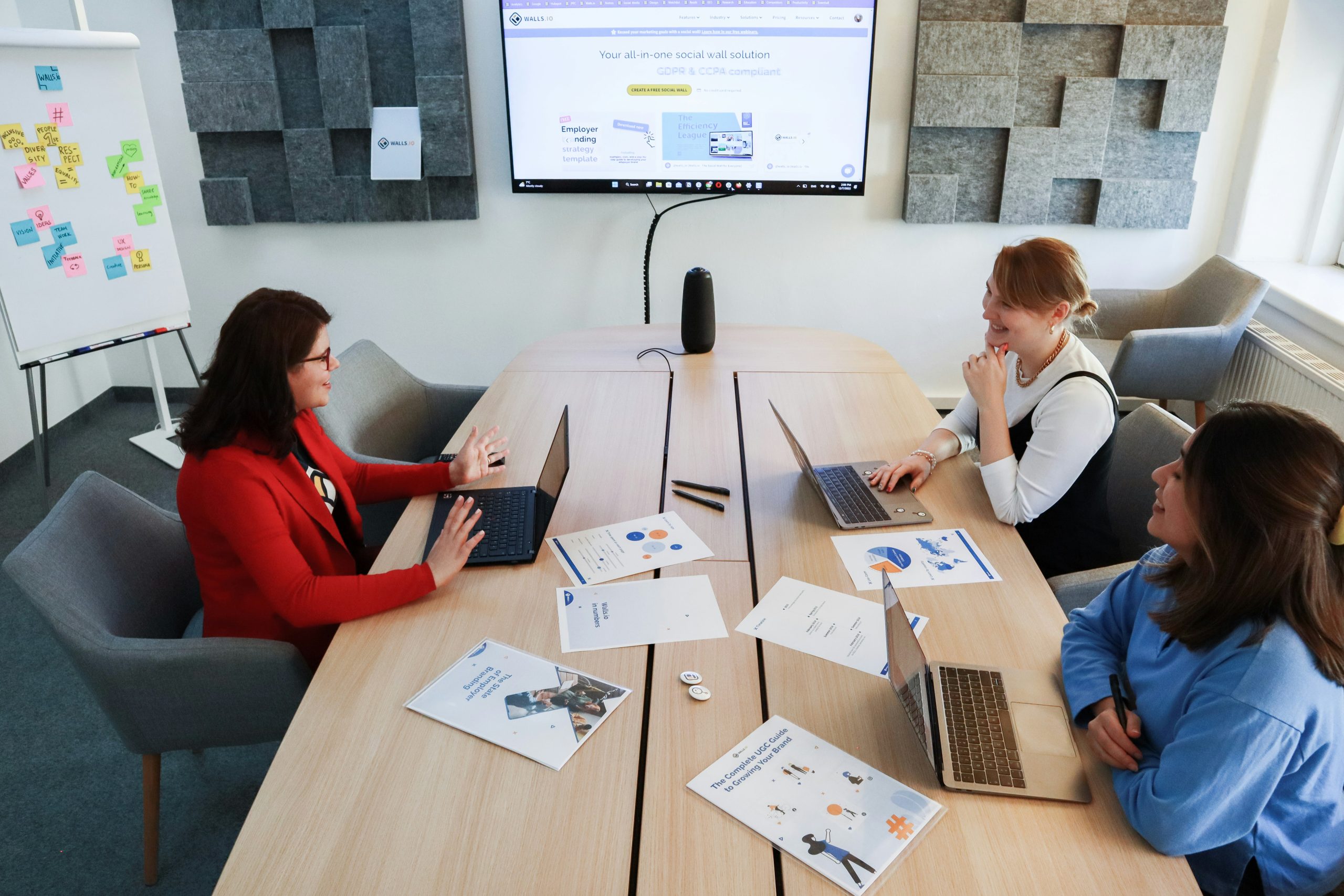 A team of professionals analyzing performance charts on a large screen, representing the strategic use of social proof and leaderboards to recruit new sub-partners in a multi-tier network.