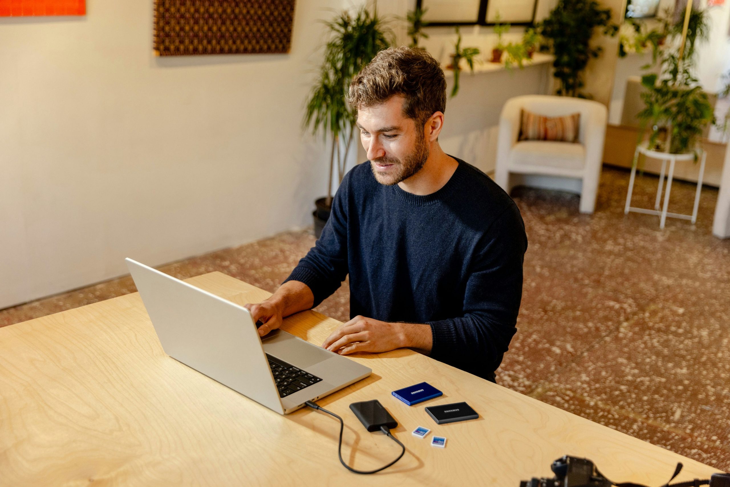 Person working on a laptop in a relaxed setting, illustrating the transition to long-term passive revenue through social trading.