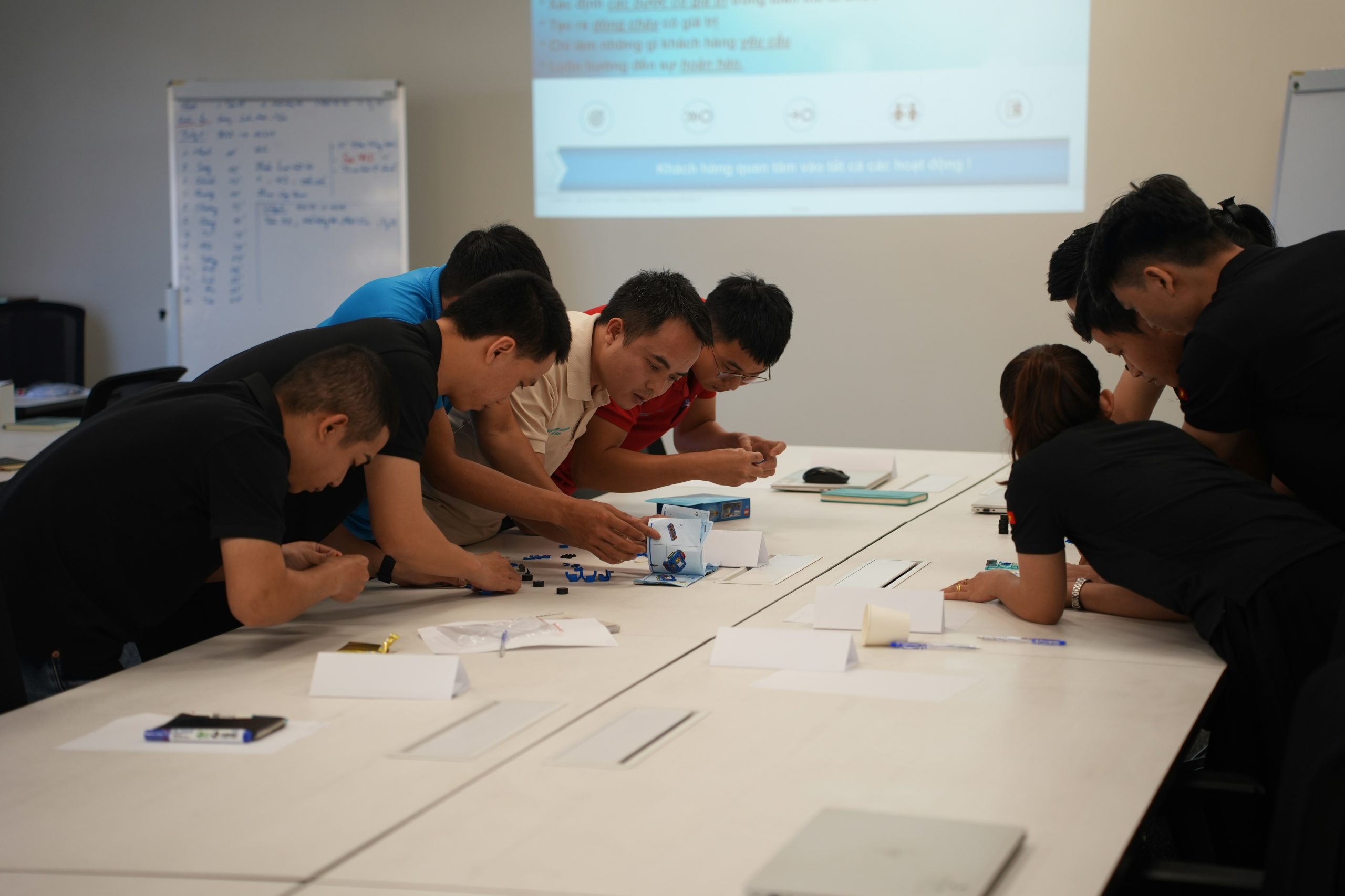 A team reviews financial performance metrics and charts on a large display, demonstrating the transparency needed to optimize a master trader's profile.